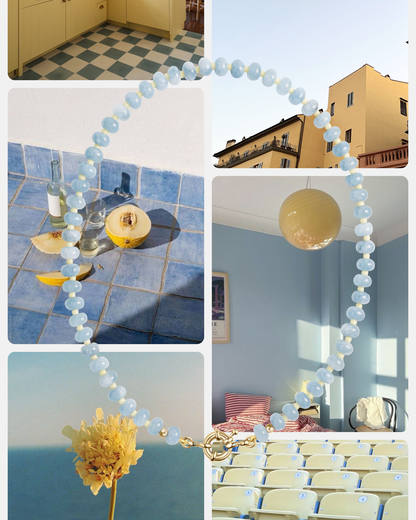 A collage shows pastel scenes: a checkered kitchen floor, yellow building, tiled table with drinks and fruit, sunlit classroom, yellow flower, and a Mod + Jo Macey Gemstone Necklace with semi-precious stones overlaid in the center.