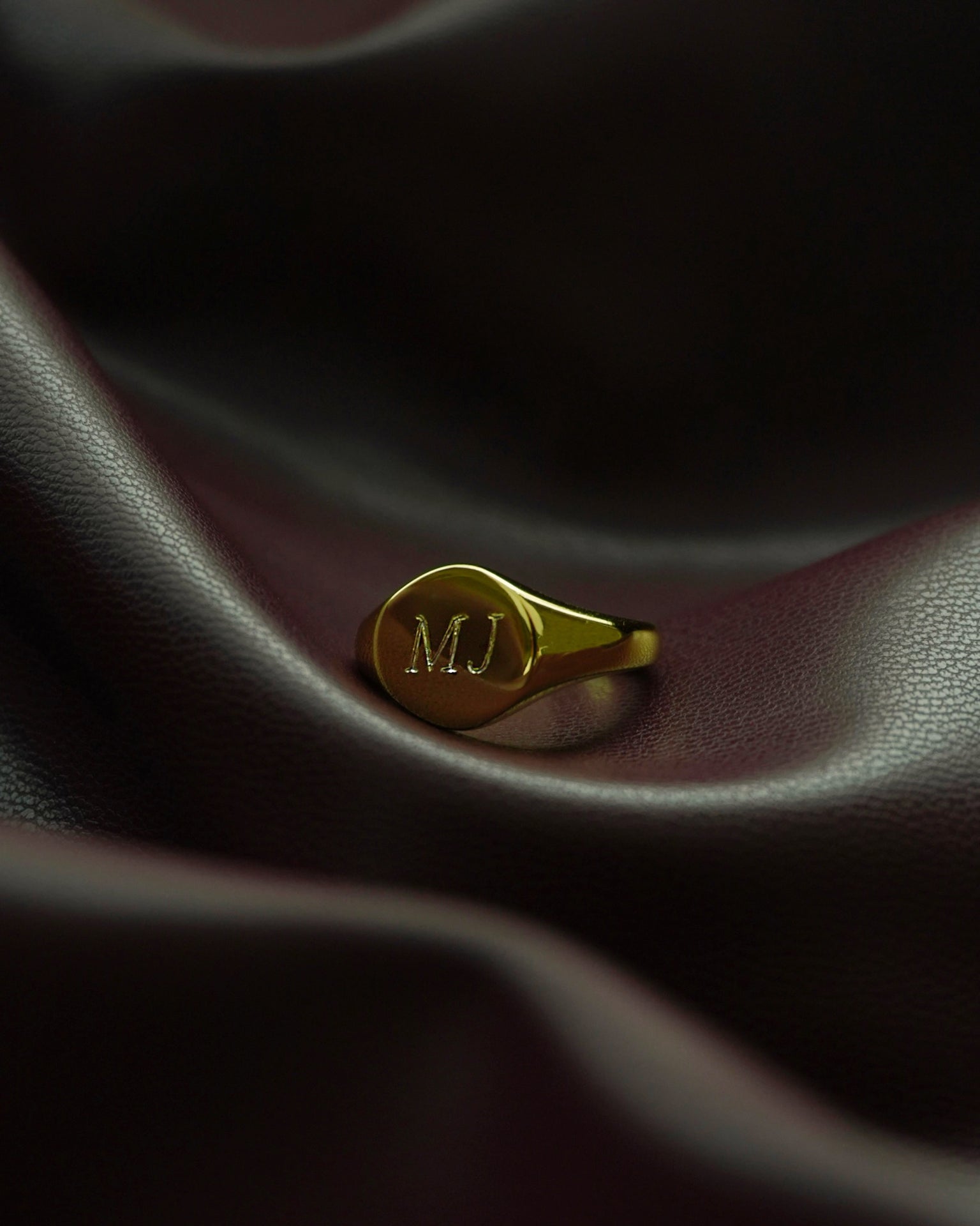 Close-up of Tessa signet ring with 'MJ' engraving, showcasing personalized jewelry and craftsmanship details.