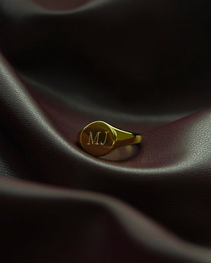 Close-up of Tessa signet ring with 'MJ' engraving, showcasing personalized jewelry and craftsmanship details.