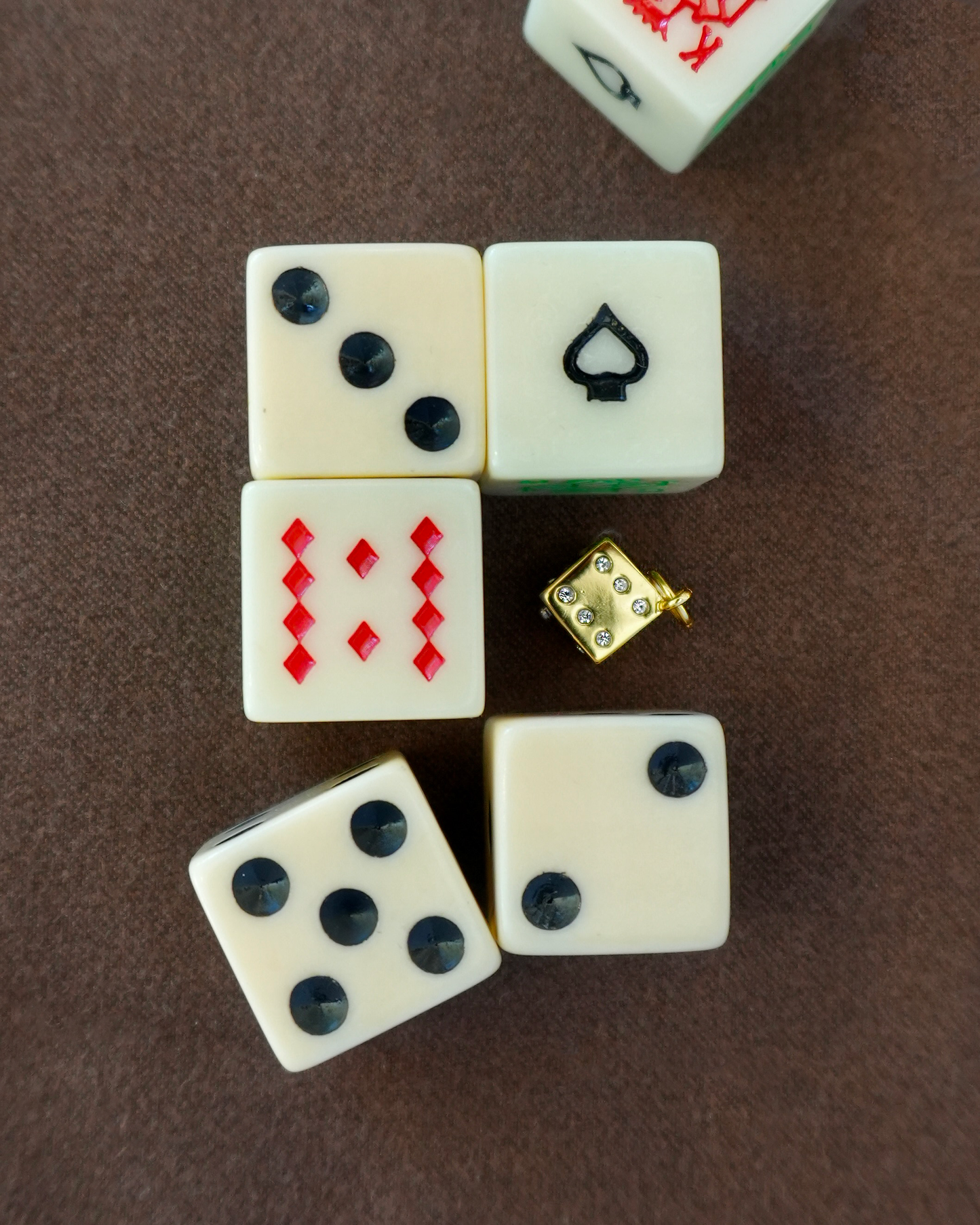 Close-up of the Jenna Dice Charm surrounded by playing dice, conveying its playful design & gaming inspiration.