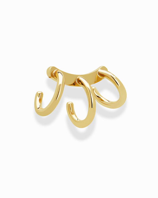 The Mod + Jo Lennon Tube Helix Ear Cuff is a shiny gold, no-piercing earring featuring three curved hooks, shown against a white background.