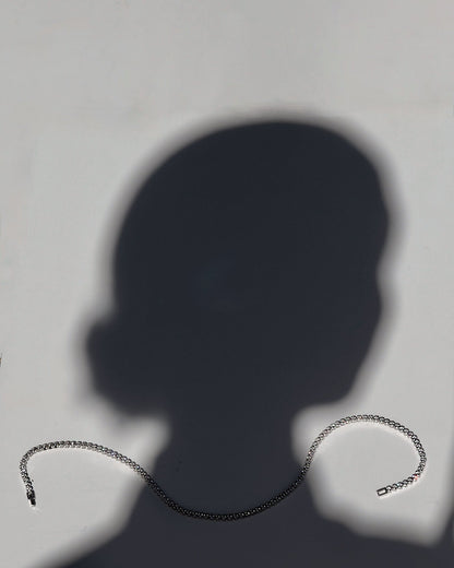 Silver chain necklace on a plain background
