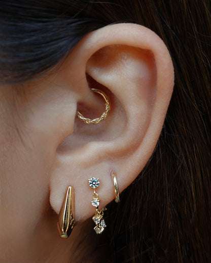 Close-up of ear piercings featuring the Lucy Chain Studs earrings, with a daith piercing for a fashionable look.
