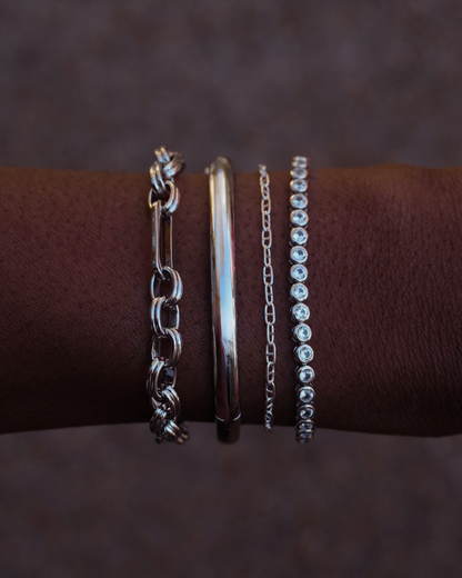 Penelope chain bracelet shown with other silver bracelets on a wrist, showcasing layering options.
