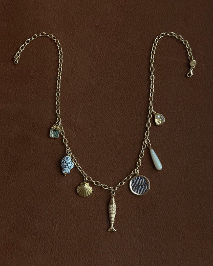 Necklace with various charms on a brown background