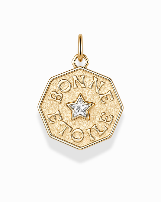 Introducing the Bonne Etoile Charm by Mod + Jo—an elegant gold octagonal pendant featuring a star-shaped gem at its center and "BONNE ETOILE" engraved around the star. This stunning piece of gold coin jewelry is perfect for anyone seeking their own lucky star necklace.