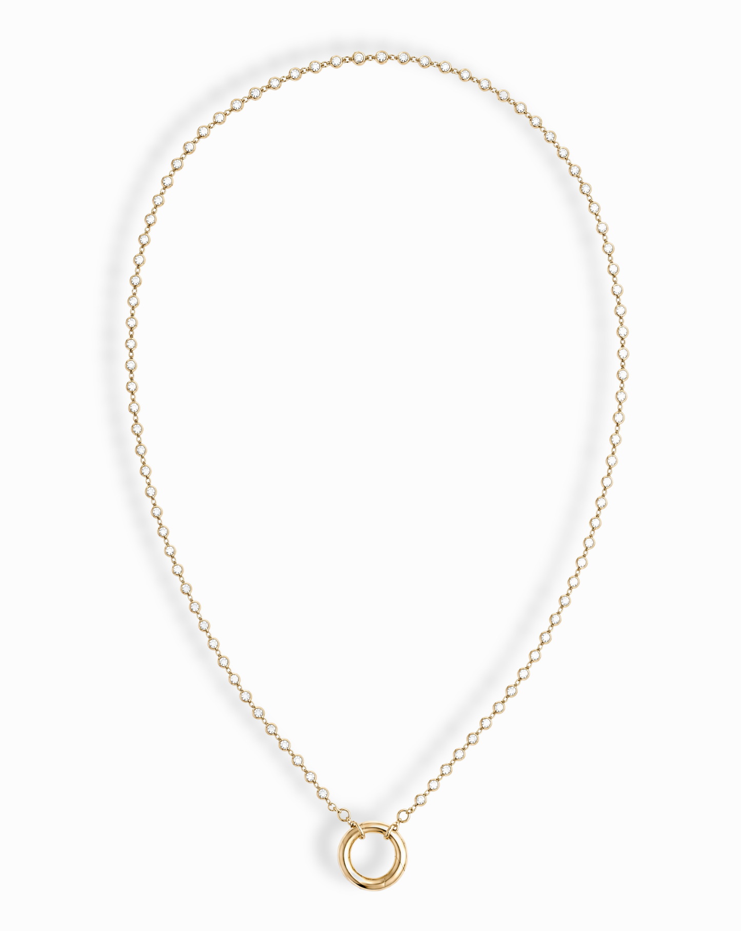 The Callum Tennis Charm Clip Necklace by Mod + Jo features a dainty gold-plated chain with a small circular pendant, elegantly displayed on a white background.