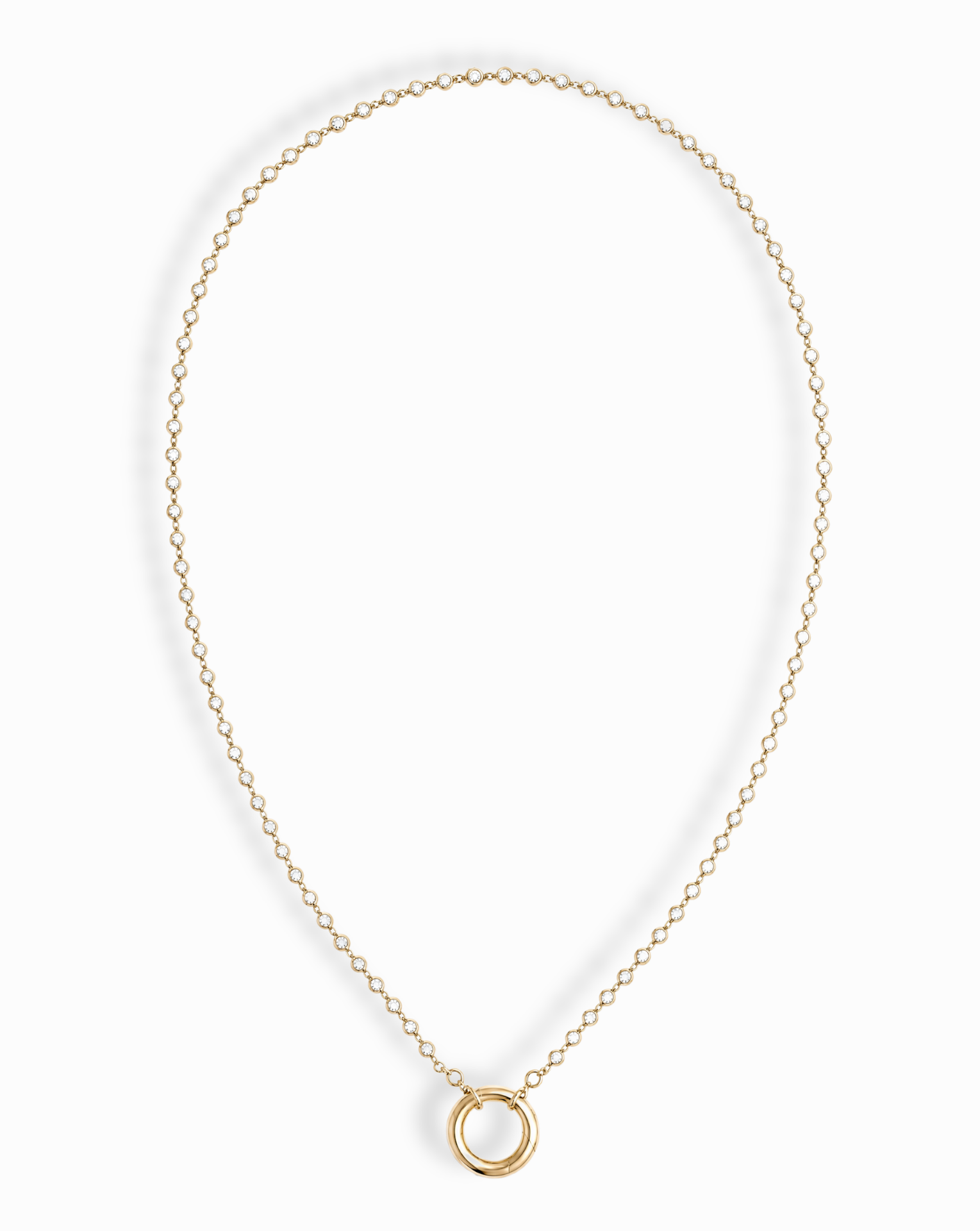 The Callum Tennis Charm Clip Necklace by Mod + Jo features a dainty gold-plated chain with a small circular pendant, elegantly displayed on a white background.