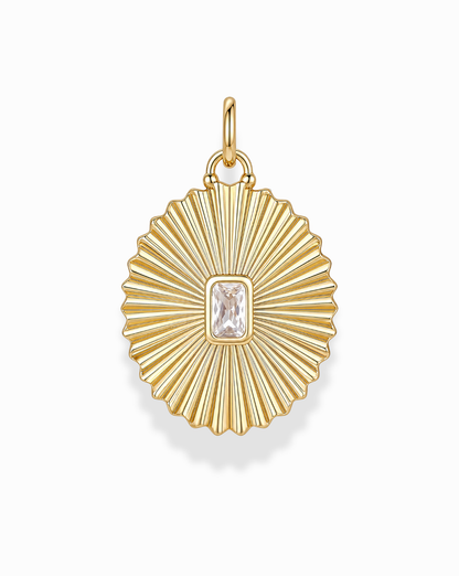 The Cora Fluted Charm by Mod + Jo showcases a radiant sunburst design, featuring an emerald-cut crystal at its center. Crafted in 14k gold, the pendant's ribbed detailing and top loop make it an elegant addition to any necklace.