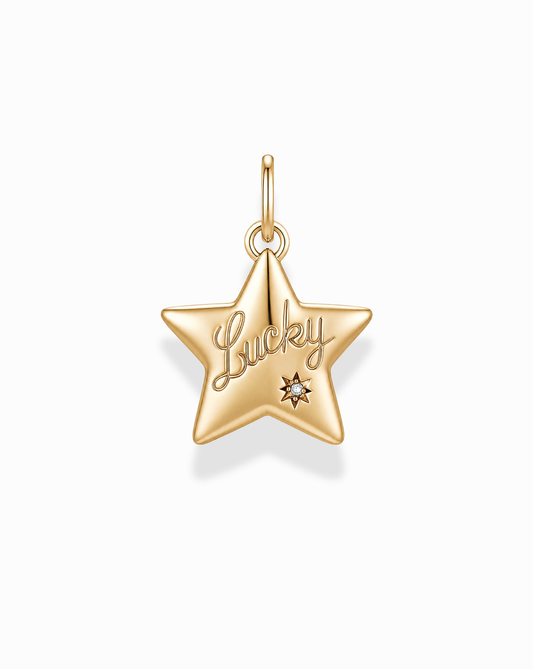 The Elara Lucky Star Charm by Mod + Jo is a gold star-shaped pendant with "Lucky" engraved on it and a delicate gemstone accent below the inscription. Crafted from 14k gold, this eye-catching charm features a top loop for easy attachment to your favorite chain, making it a charming everyday accessory.