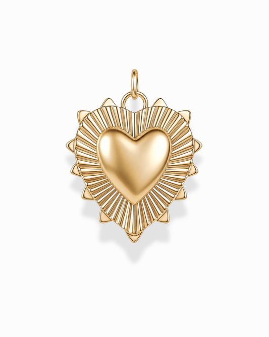 The Grande Lynn Engravable Heart Charm by Mod + Jo features a gold heart pendant with a raised center and a radiating sunburst pattern along the edges, expertly crafted in 14k gold over brass. Photographed on a white background, this customizable piece brings a timeless touch to any jewelry collection.