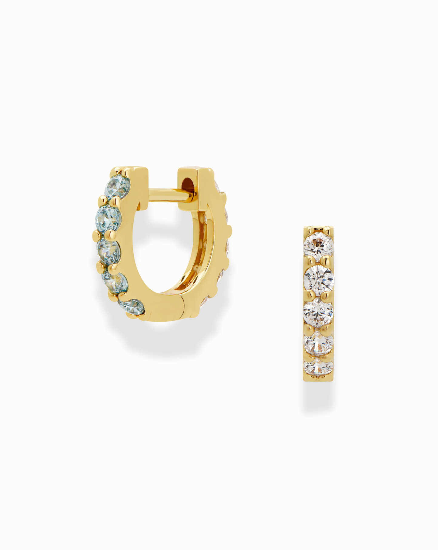 The Mod + Jo Harlow Reversible Birthstone Huggies are small 18k gold-plated hoops, each featuring a row of clear round gemstones along the front. One is shown open, and the other highlights the gem-studded side.