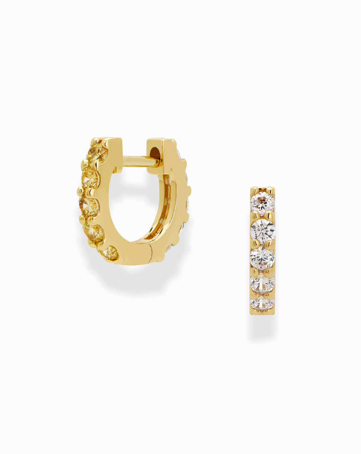 The Harlow Reversible Birthstone Huggies by Mod + Jo are small gold plated hoops with round white gemstones along the front, shown in side and front views on a white background.