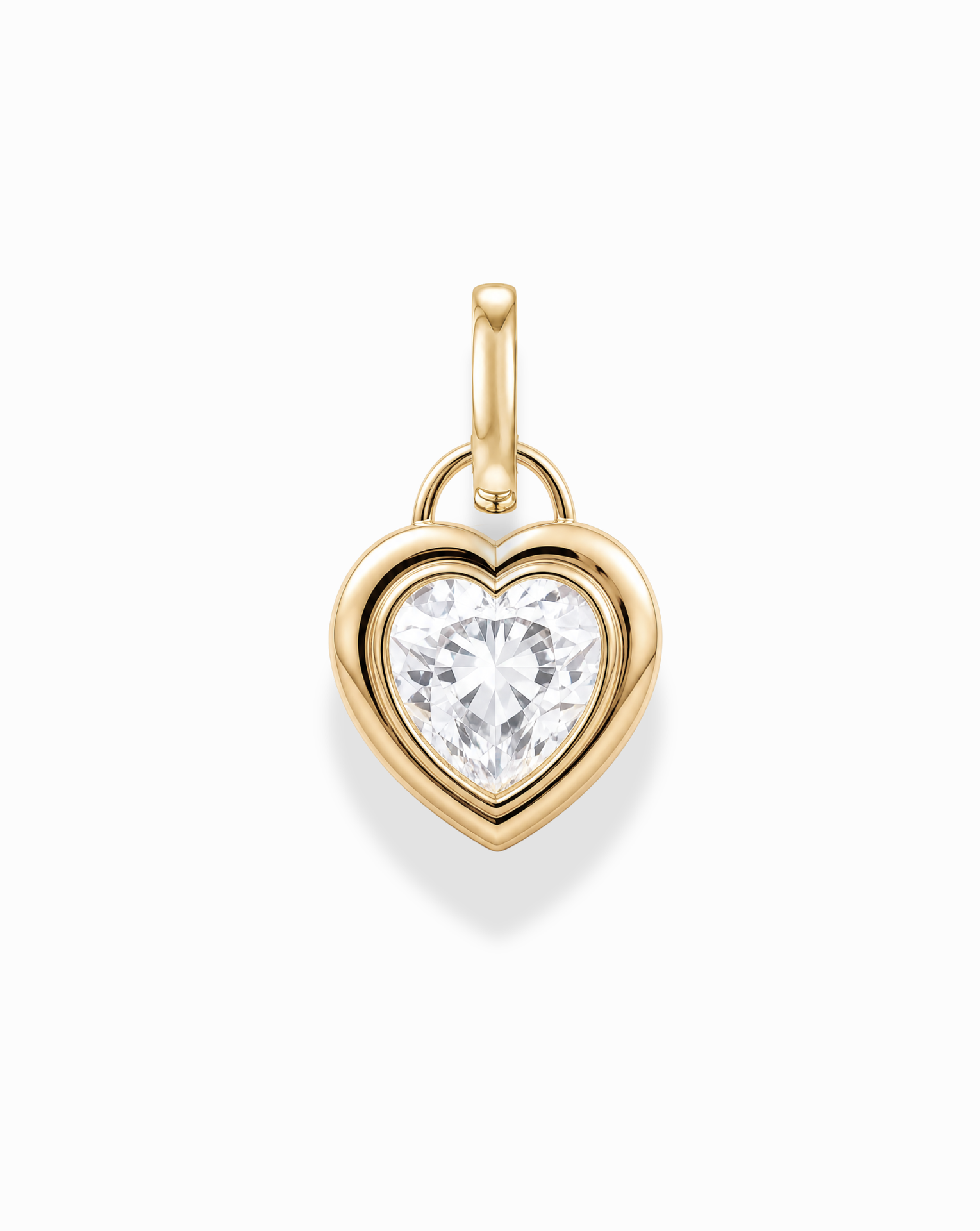The Mod + Jo Jovie Sapphire Heart Charm is a 14k gold pendant with a large, round-cut lab-grown white sapphire at its center, displayed against a white background.
