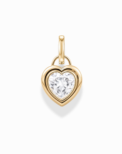 The Mod + Jo Jovie Sapphire Heart Charm is a 14k gold pendant with a large, round-cut lab-grown white sapphire at its center, displayed against a white background.