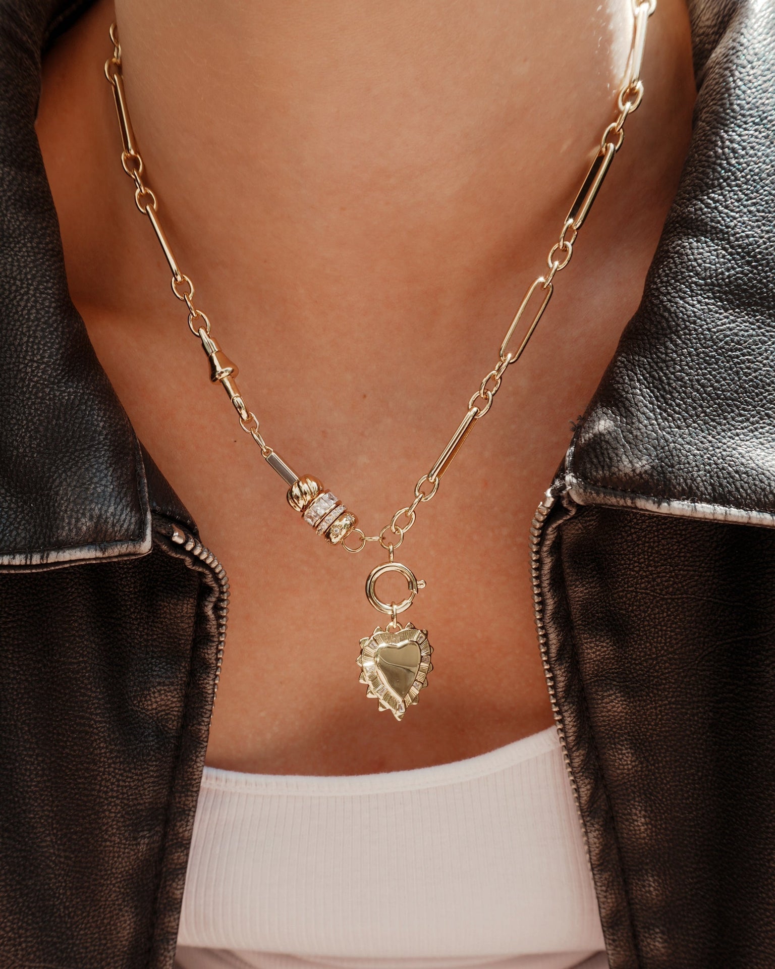 A close-up of a person wearing the Mod + Jo Liam Space Bar Chain Necklace, layered with beaded accents over a white top and dark leather jacket.