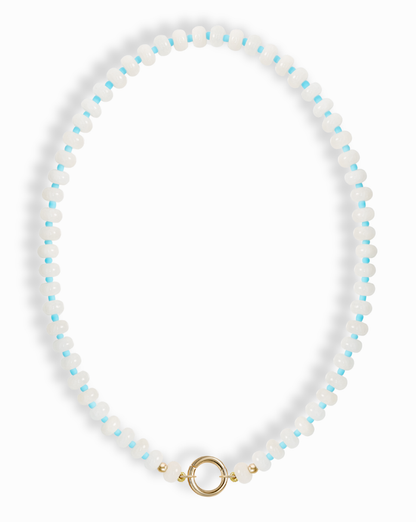 The Macey Gemstone Necklace by Mod + Jo features alternating white jade and light blue round beads, finished with a gold circular clasp at the bottom center.