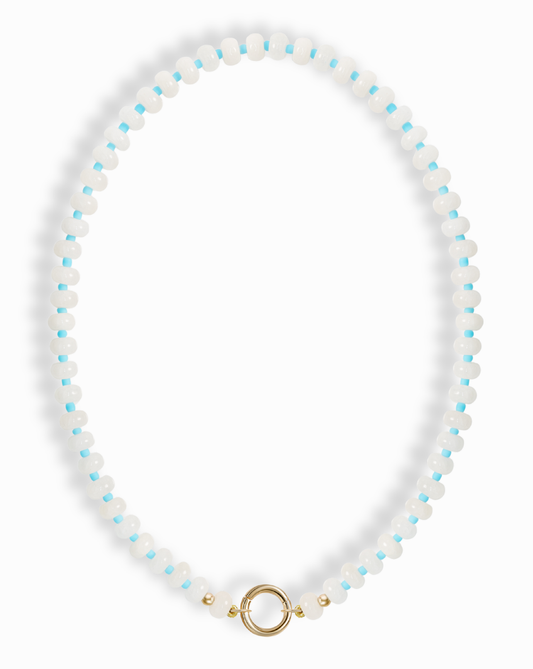 The Macey Gemstone Necklace by Mod + Jo features alternating white jade and light blue round beads, finished with a gold circular clasp at the bottom center.