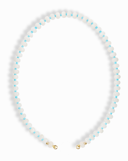 The Macey Gemstone Necklace by Mod + Jo features alternating small white jade and light blue beads in a circular pattern, finished with gold-colored clasps.