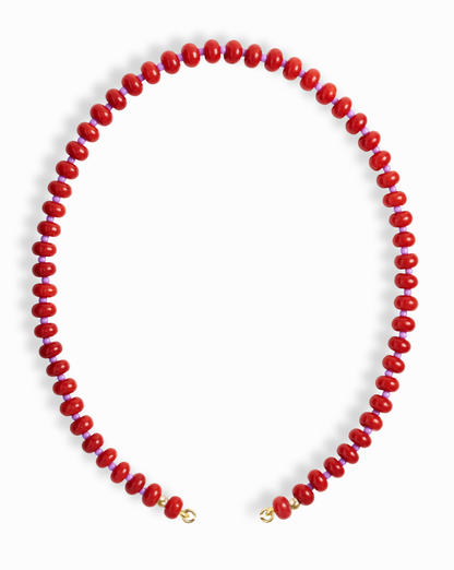The Mod + Jo Macey Gemstone Necklace features evenly spaced round red natural semi-precious stones with small gold clasps at each end, arranged in an open circle on a white background.