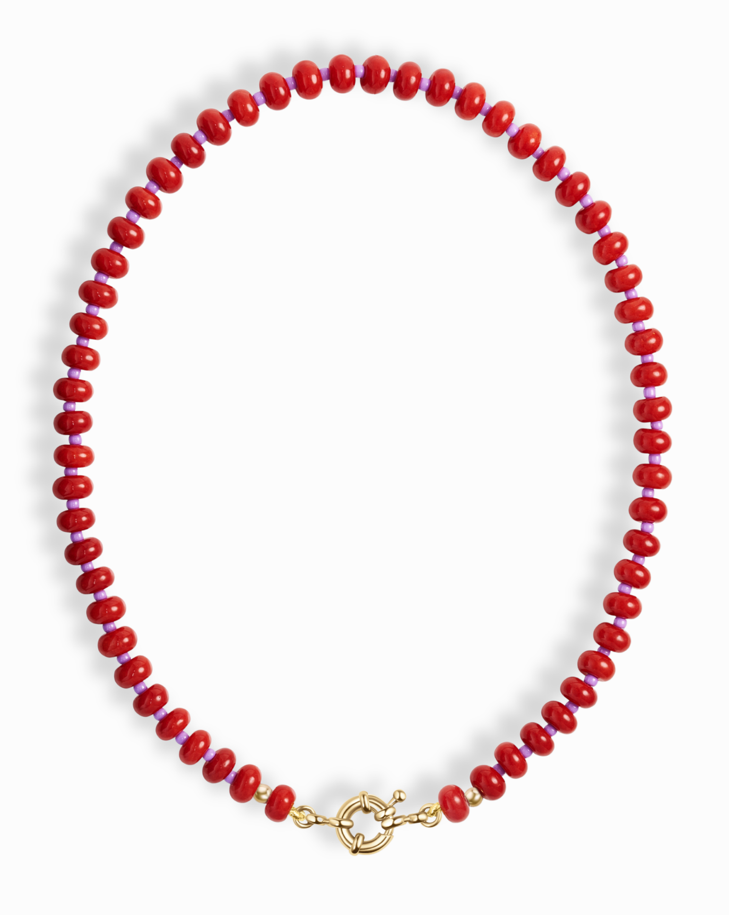 The Macey Gemstone Necklace by Mod + Jo features round, glossy red beads and a gold toggle clasp, artfully displayed in a circular shape on a white background.