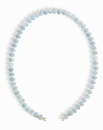 The Macey Gemstone Necklace by Mod + Jo features round, light blue beads with white marbling, strung in a single strand and finished with small gold clasps.