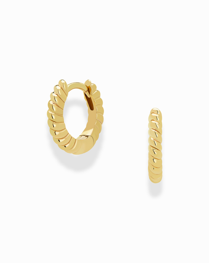 The Petite Margaux Stacking Hoops by Mod + Jo are small gold, tarnish-resistant earrings with a twisted, ridged design, shown on a white background—one hoop faces forward while the other is displayed in profile.
