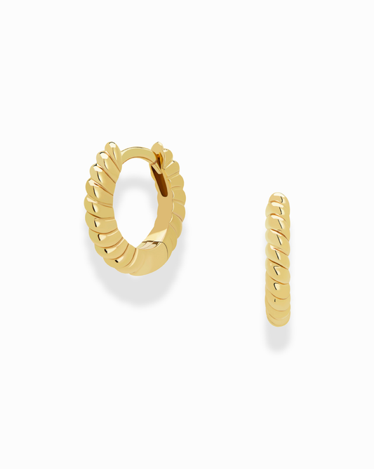 The Petite Margaux Stacking Hoops by Mod + Jo are small gold, tarnish-resistant earrings with a twisted, ridged design, shown on a white background—one hoop faces forward while the other is displayed in profile.