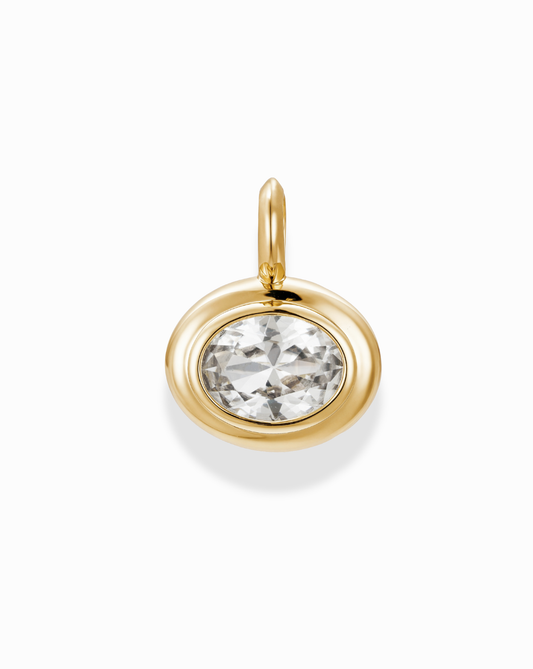 The Marla Sapphire Bezel Charm by Mod + Jo features a large, round lab-grown gemstone set in a gold bezel, displayed against a white background.