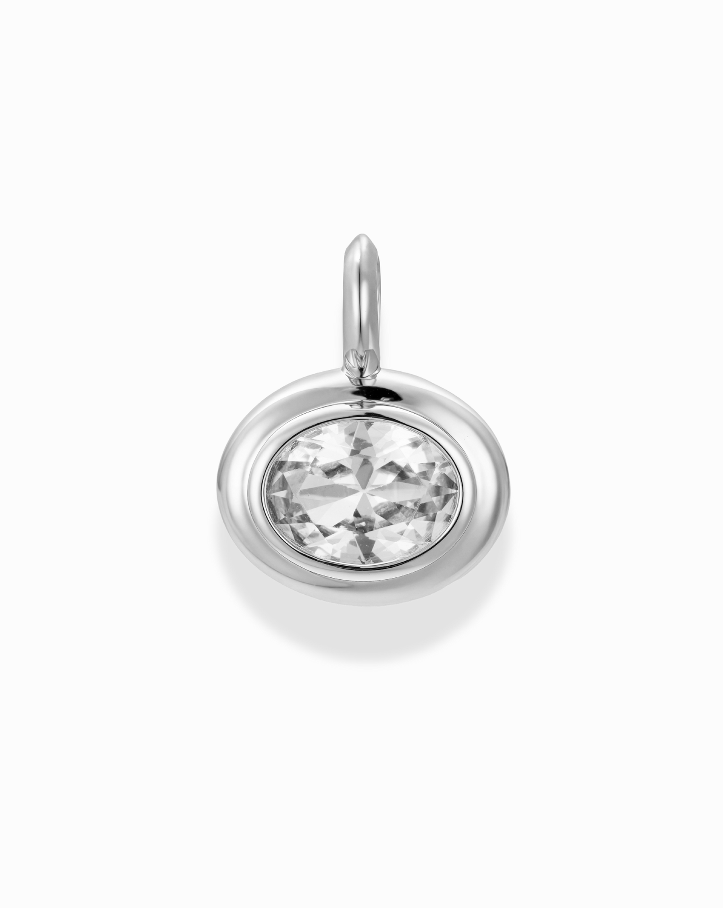 Close-up of a "Marla Sapphire Bezel Charm" pendant showcasing the gemstone. Jewelry design with silver bezel.