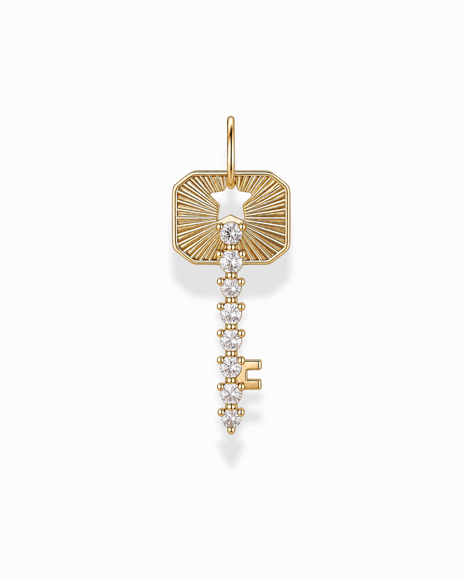 The Noah Key Charm by Mod + Jo is a gold plated, key-shaped pendant embellished with sparkling white gemstones. Featuring a rectangular top with a star-shaped cutout and an intricate, decorative design on a white background, this elegant charm is symbolic jewelry perfect for any occasion.