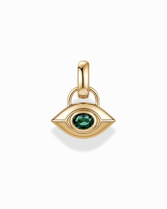 The Mod + Jo Nyx Evil Eye Charm is a gold, eye-shaped pendant featuring a green gemstone at its center, designed with a smooth finish and an attachment loop, shown against a white background.