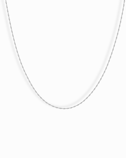 The Odette Barley Chain Necklace, crafted from delicate sterling silver, is displayed against a plain white background, its thin barley chain forming a gentle curve.