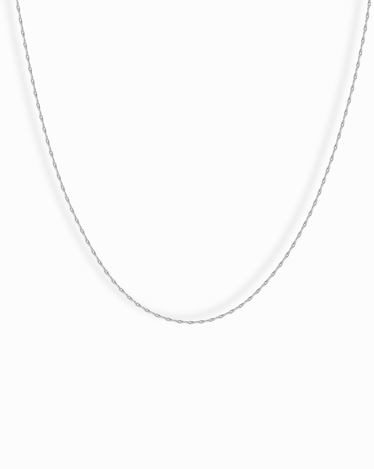 The Odette Barley Chain Necklace, crafted from delicate sterling silver, is displayed against a plain white background, its thin barley chain forming a gentle curve.