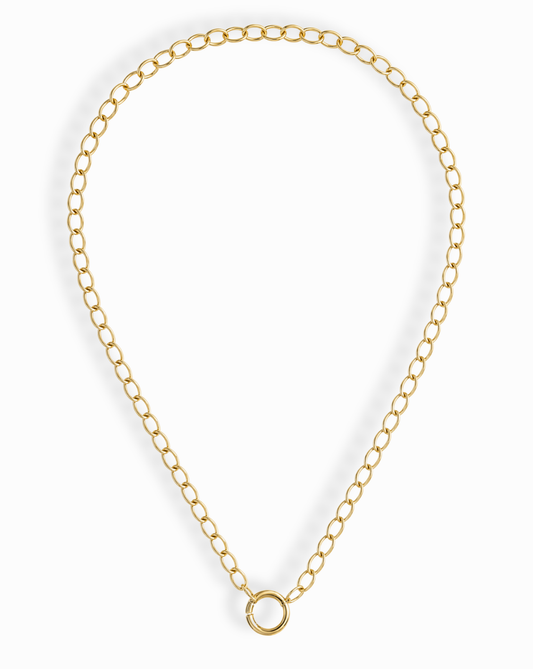 The Presley Charm Clip Necklace by Mod + Jo features 14k gold plating, evenly spaced oval links, and a central circular clasp—ideal as a base chain for charms. Shown against a white background.