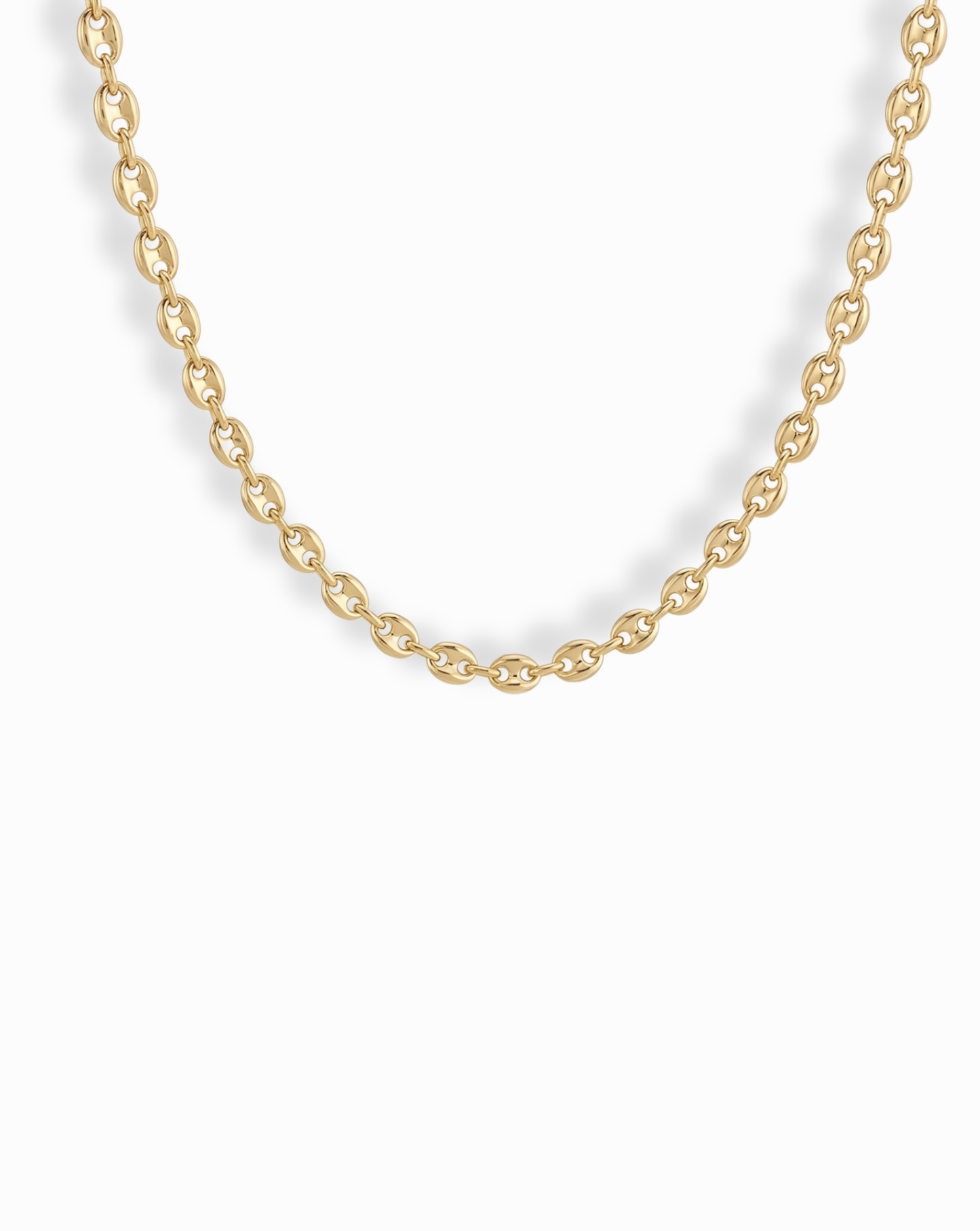 A close-up of the Mod + Jo Romee Puffy Mariner Necklace, featuring elegant oval links in 14k gold. The partially shown chain forms a gentle curve against a white background, highlighting its refined anchor link design.