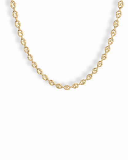 A close-up of the Mod + Jo Romee Puffy Mariner Necklace, featuring elegant oval links in 14k gold. The partially shown chain forms a gentle curve against a white background, highlighting its refined anchor link design.