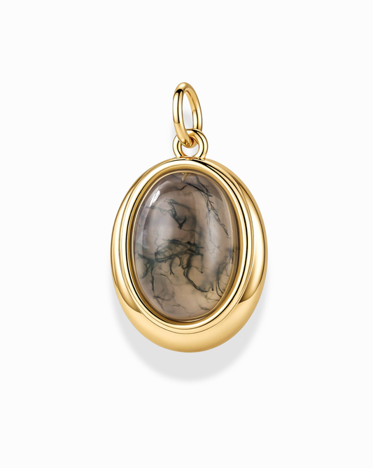 The Rory Gemstone Charm by Mod + Jo features a polished cabochon Moss Agate gemstone with green and beige patterns, set in a smooth gold oval frame complete with a loop for easy attachment to your favorite chain. This earthy charm beautifully complements any gold plated necklace, offering an elegant, nature-inspired accent to your jewelry collection.