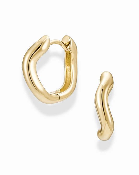 Close-up of Sloan Wavy Huggies earrings, showcasing the modern gold design and subtle curve for a comfortable fit.