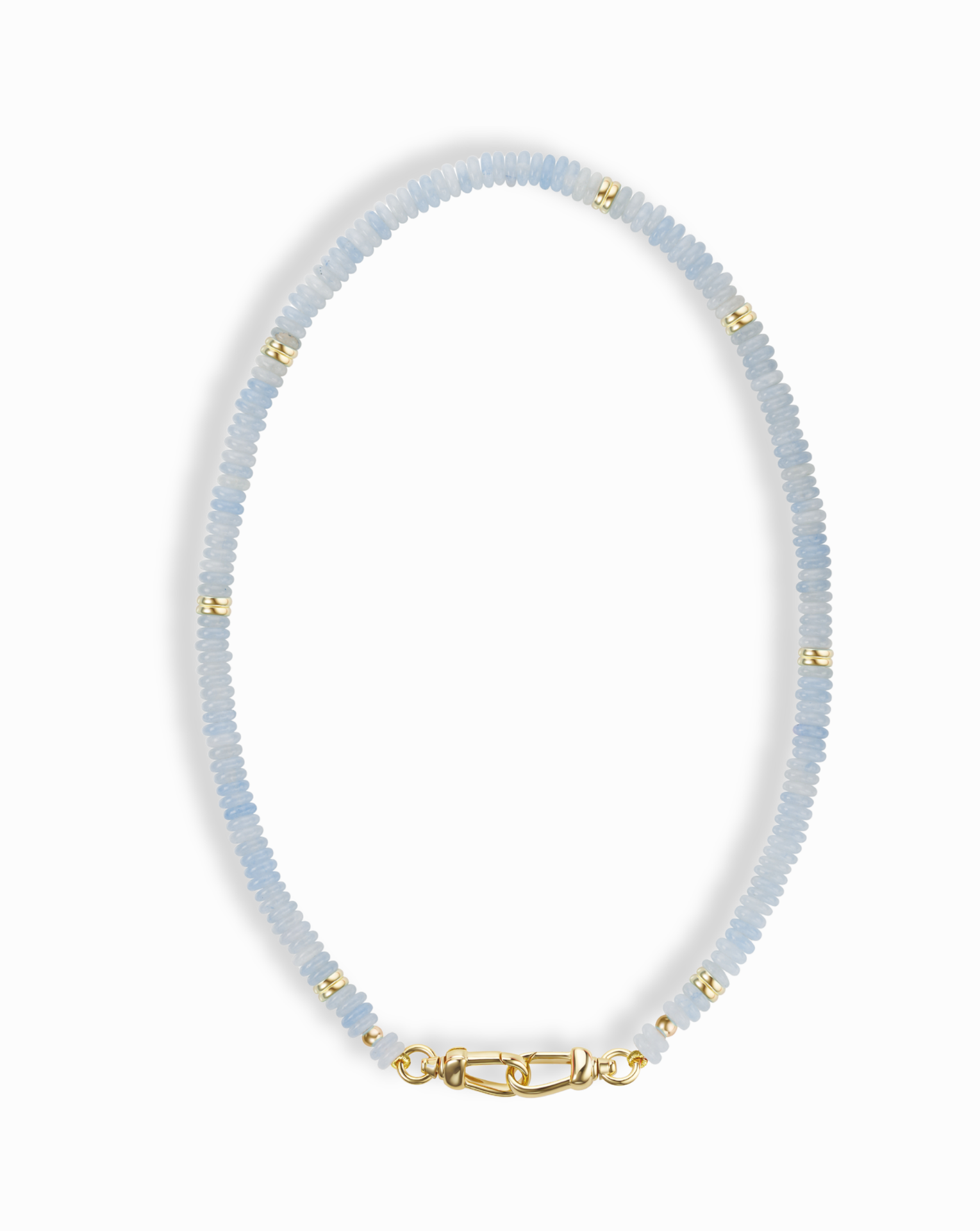 The Sonia Gemstone Necklace by Mod + Jo features light blue aquamarine beads, gold spacer accents, and a gold clasp—a stunning piece of handmade jewelry.