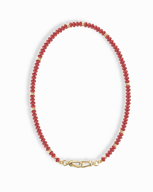 Close-up of the Sonia Gemstone Necklace, featuring red beads with gold accents and a unique gold clasp.