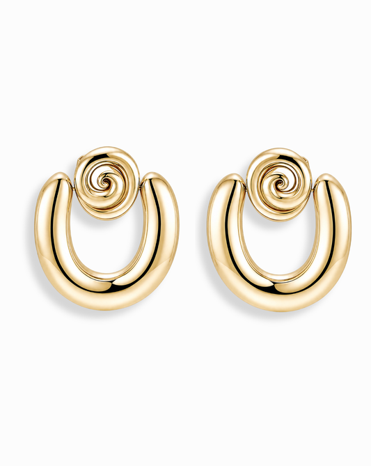 The Mod + Jo Sabine Statement Earrings are shiny 14k gold pieces with a bold, curved U-shape and spiral design at the top, shown against a plain white background.