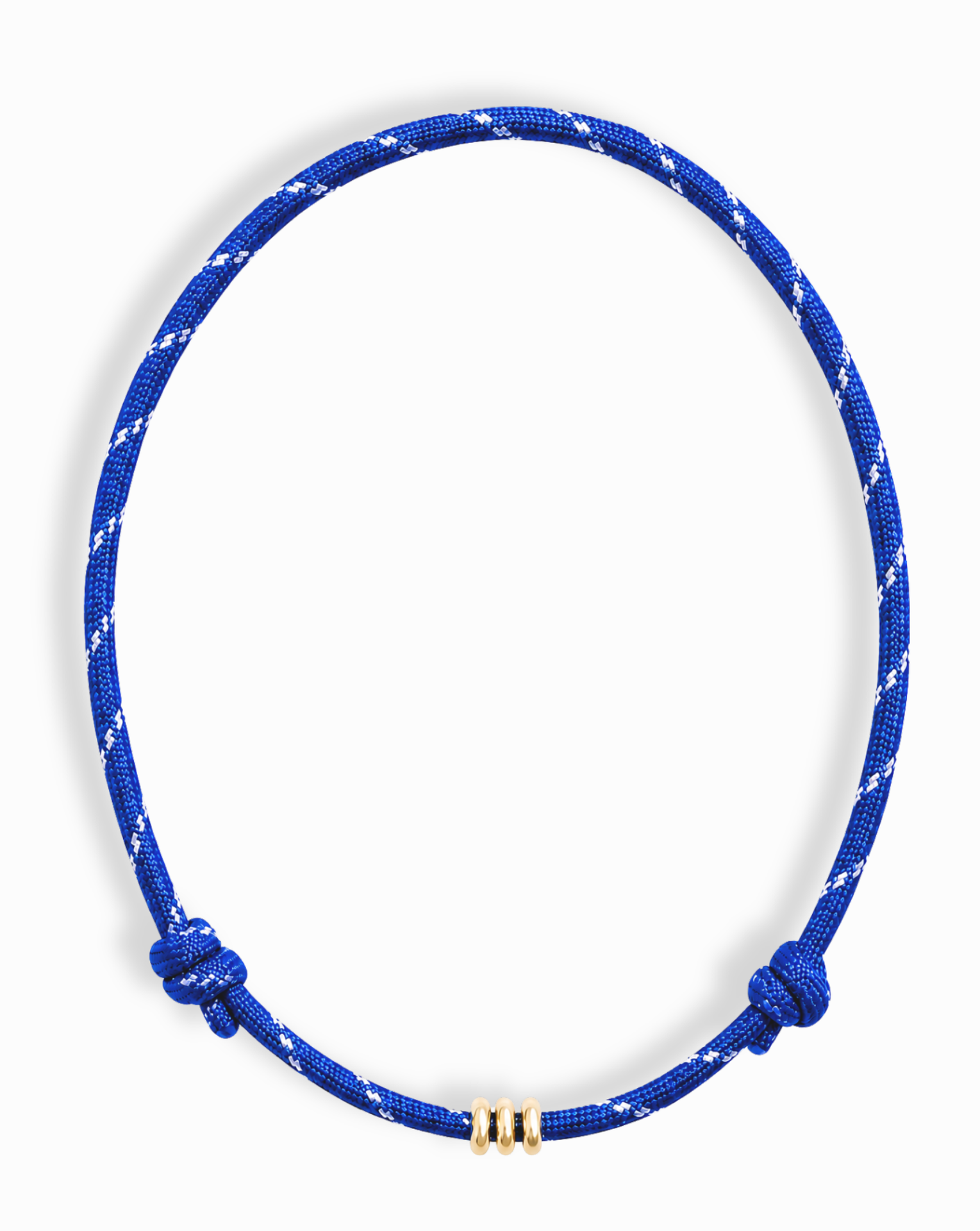 The Mod + Jo Tommy Cord Necklace features blue and white diagonal stripes with three gold-plated spacer beads at the center and adjustable sliding knots, shown on a white background.