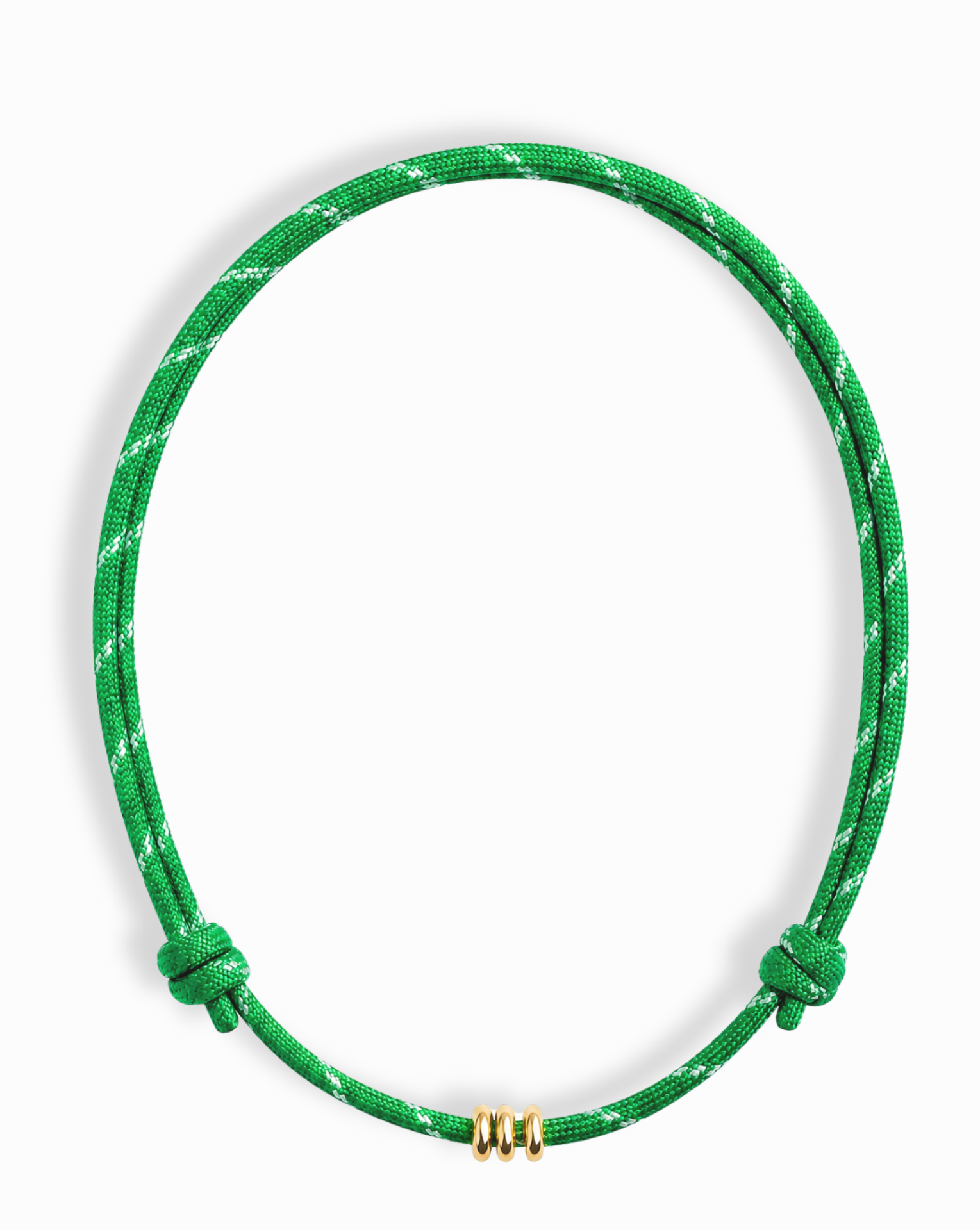 The Tommy Cord Necklace by Mod + Jo is a green paracord necklace with white accents, two adjustable knots, and three small gold-plated rings at the bottom, shown against a white background.