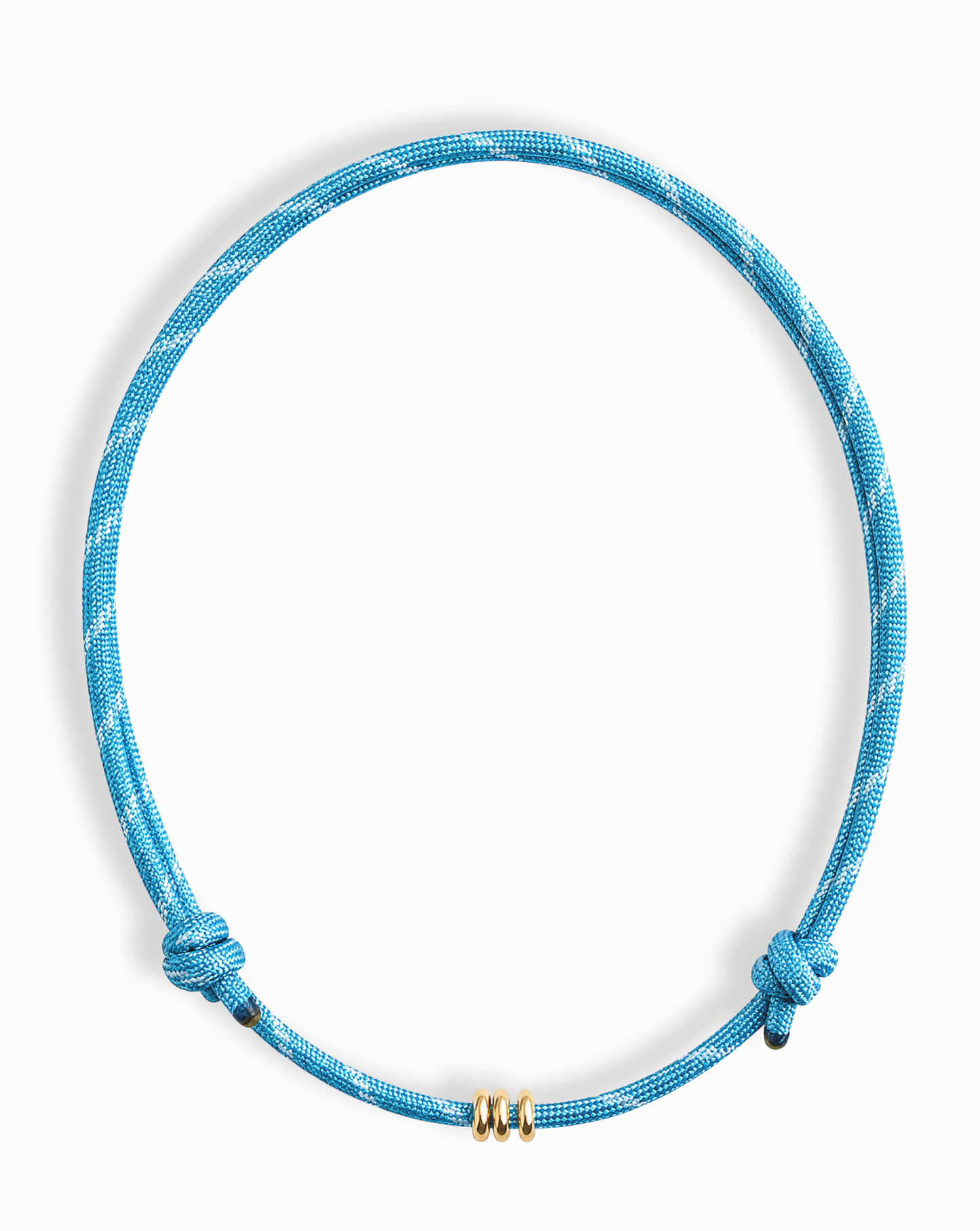 The Mod + Jo Tommy Cord Necklace is a blue paracord necklace with two side knots and three gold-plated spacers at the center, shown on a white background.