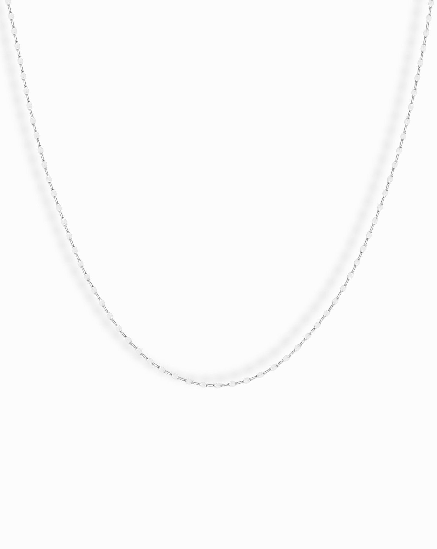 The Winnie Sparkle Chain Necklace, a thin sterling silver piece, is displayed against a plain white background—ideal for elegant layering.