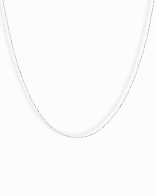 The Winnie Sparkle Chain Necklace, a thin sterling silver piece, is displayed against a plain white background—ideal for elegant layering.